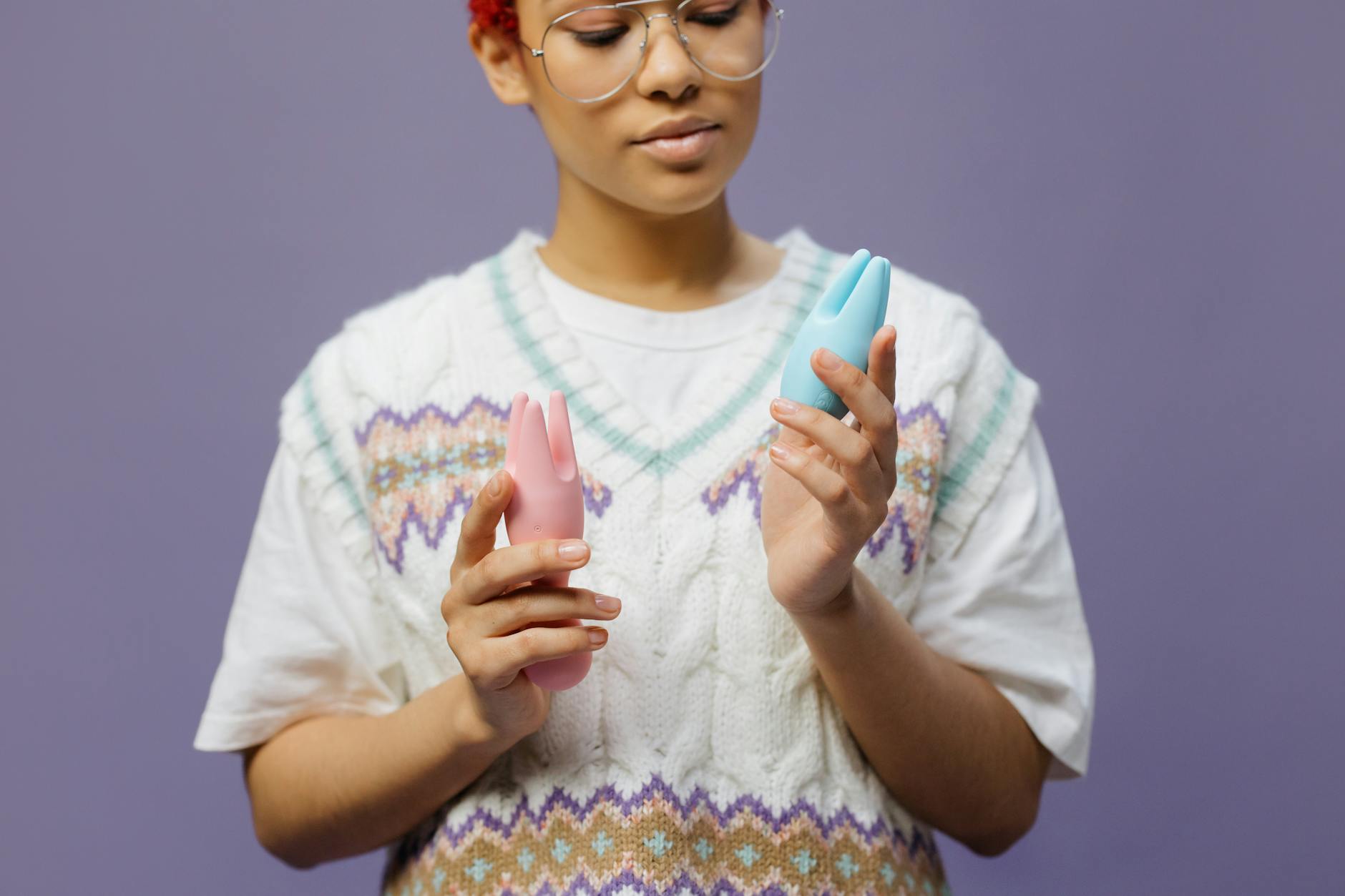 青とピンクのシリコンバイブレーターを手に持つ女性